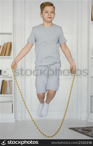 full shot boy jumping rope indoors