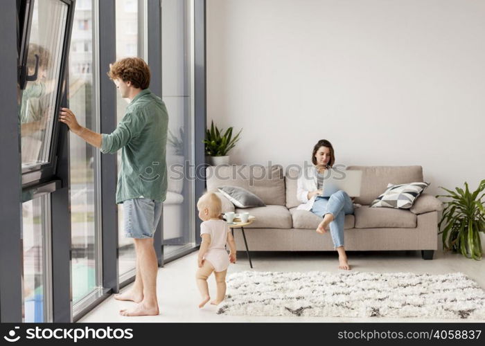 full shot couple with baby living room