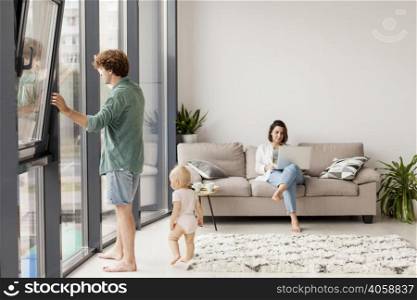 full shot couple with baby living room