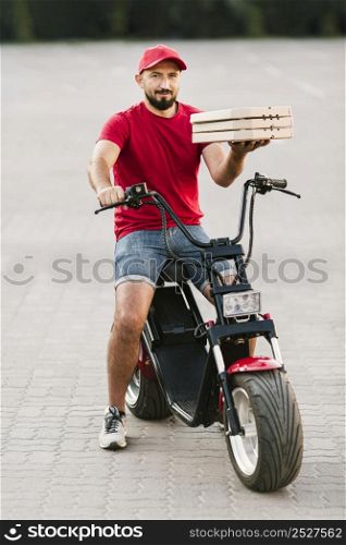 full shot delivery guy holding pizza boxes