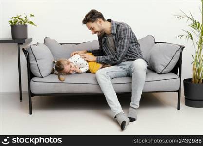 full shot father tickling girl