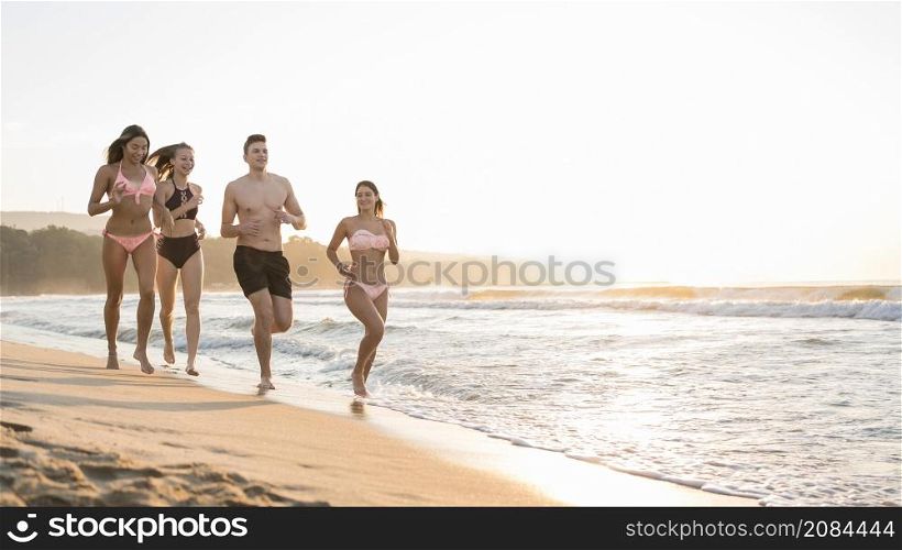 full shot friends running together shore