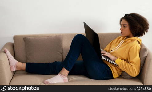 full shot girl couch with laptop