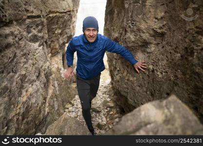 full shot male walking through rocks