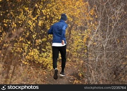 full shot man running trail forest