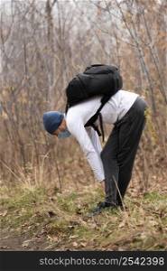 full shot man with face mask backpack woods