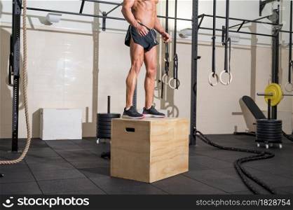 Full shot of a fit young caucasian sportsman training alone doing box jump exercise in the gym. High quality photo.. Full shot of a fit young caucasian sportsman training alone doing box jump exercise in the gym.