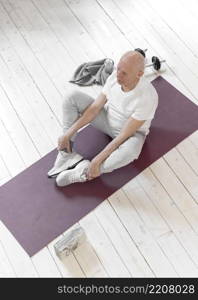 full shot senior man sitting yoga mat