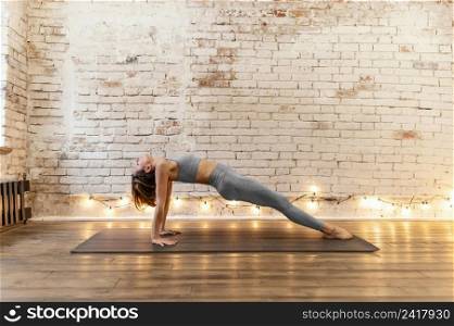 full shot senior woman stretching indoors