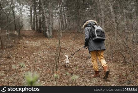 full shot traveler walking dog forest