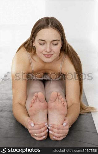full shot woman holding her feet