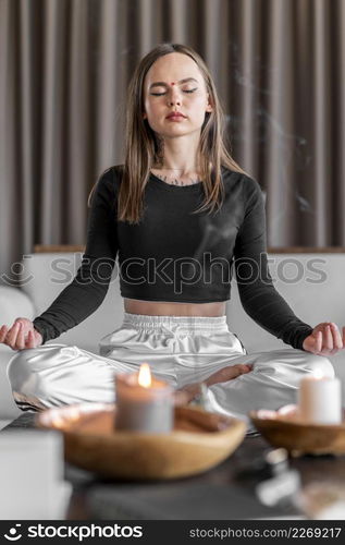 full shot woman meditating couch