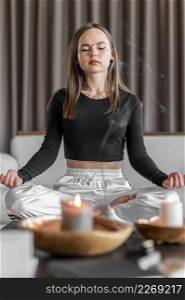 full shot woman meditating couch