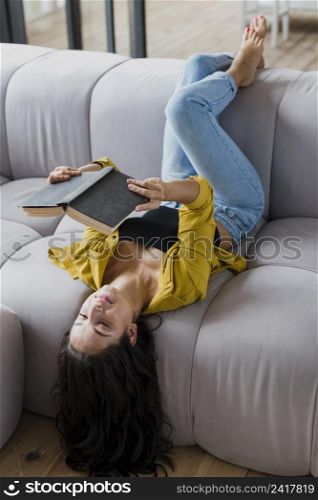 full shot woman reading couch