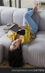 full shot woman reading couch