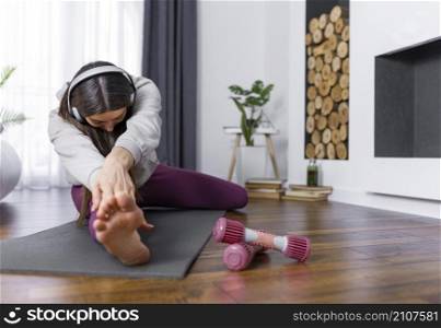 full shot woman stretching leg
