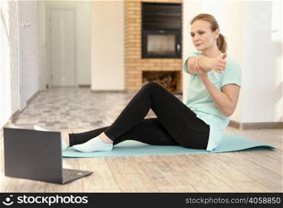 full shot woman stretching with laptop