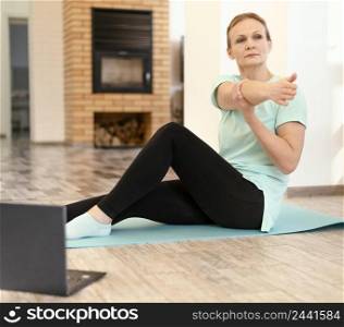 full shot woman training with laptop indoors