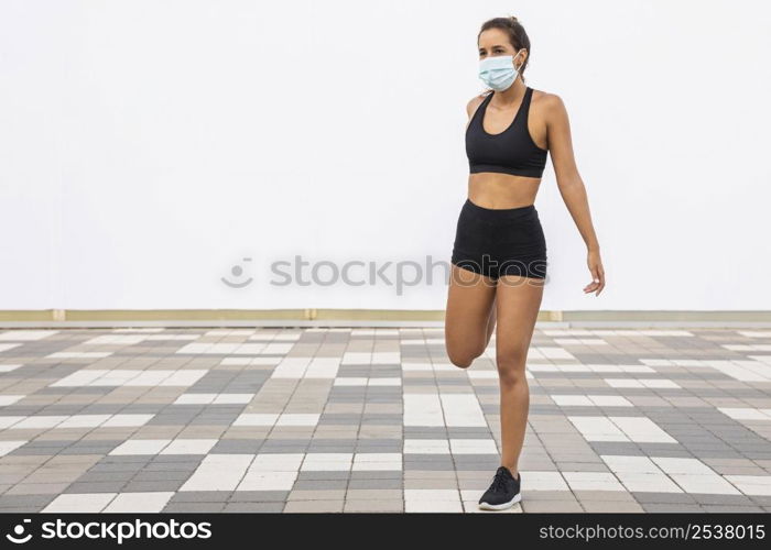 full shot woman with mask stretching