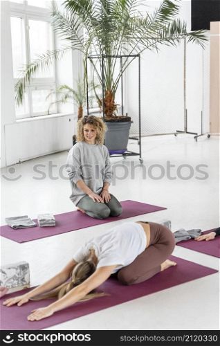 full shot woman yoga mat stretching
