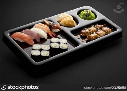 full sushi menu on tray on black background
