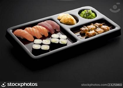 full sushi menu on tray on black background