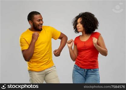 fun and people concept - happy smiling african american couple dancing over grey background. happy smiling african american couple dancing