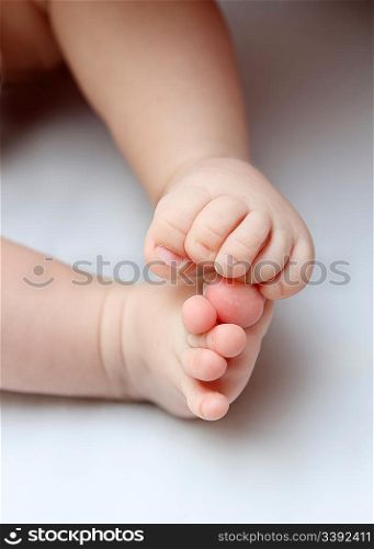 fun baby legs close-up on white sheet