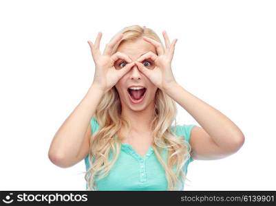 fun, emotions, expressions and people concept - smiling young woman or teenage girl looking through glasses made of fingers