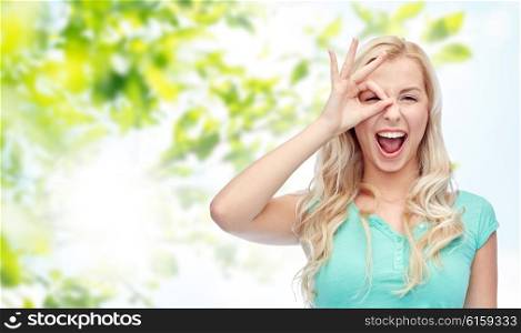 fun, emotions, expressions, summer and people concept - smiling young woman or teenage girl making ok hand gesture over green natural background