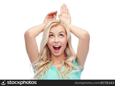 fun, expressions, easter and people concept - happy smiling young woman making bunny ears