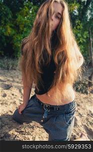 Fun picture of a long haired blonde on sand with bare belly