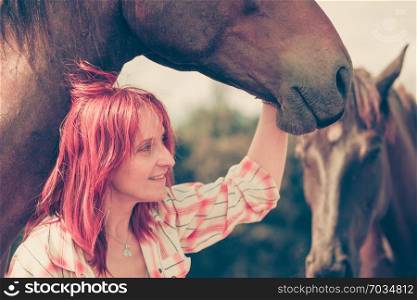 Fun with animals, animal love concept. Western redhead woman hugging horse. Western animal lover woman hugging horse