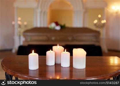 funeral and mourning concept - burning candles and coffin at church. burning candles and coffin in church at funeral
