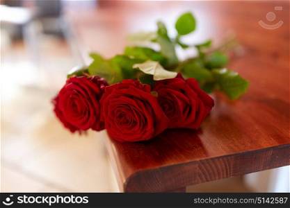 funeral and mourning concept - red roses on bench in church. red roses on bench at funeral in church
