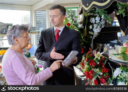 Funeral director showing woman a memorial plaque