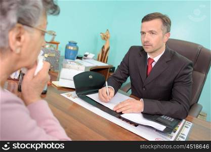 Funeral director talking to bereaved woman