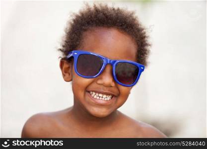 Funny Afro-American kid with blue sunglasses and a beautiful smile