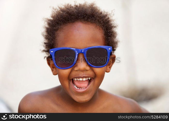 Funny Afro-American kid with blue sunglasses and a beautiful smile