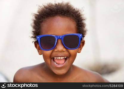 Funny Afro-American kid with blue sunglasses and a beautiful smile