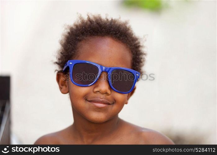 Funny Afro-American kid with blue sunglasses and a beautiful smile