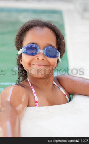 Funny afroamerican girl with goggles cooling off in the pool