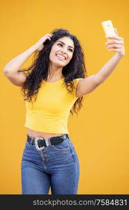 Funny Arab woman taking selfie photograph with smartphone. Curly hair female.. Young Arab woman taking selfie photograph with smartphone.