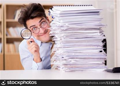 Funny auditor checking reports with magnifying glass