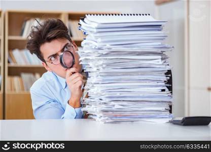 Funny auditor checking reports with magnifying glass