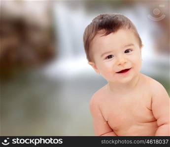 Funny baby smiling on a unfocused background with water