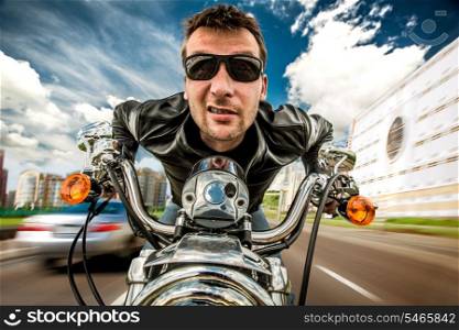 Funny Biker in sunglasses and leather jacket racing on the road (fisheye lens)