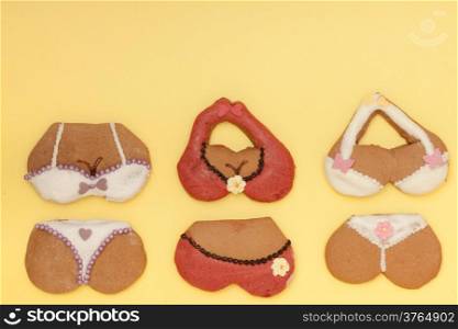 Funny bikini shape gingerbread cakes cookies sweet dessert with icing and decoration on yellow paper background