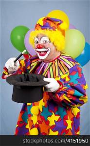 Funny birthday clown does magic tricks with a top hat and wand.