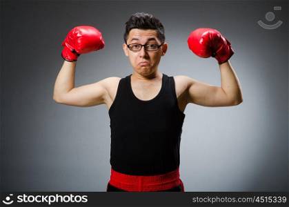 Funny boxer with red gloves against dark background